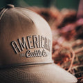 Close-up of the ACC Waxed Canvas hat in khaki, featuring bold embroidered text 