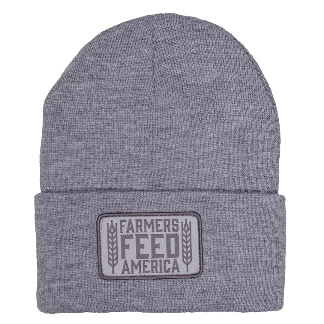 Rural Cloth's Farmers Feed America Beanie is a gray knit beanie with a folded brim, adorned with a rectangular patch that reads "Farmers Feed America" and featuring two wheat illustrations. This beanie pays tribute to the hard-working men and women who cultivate our land.