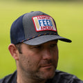 A man wearing the Farmers Feed America Hat by Rural Cloth, featuring a patch with 