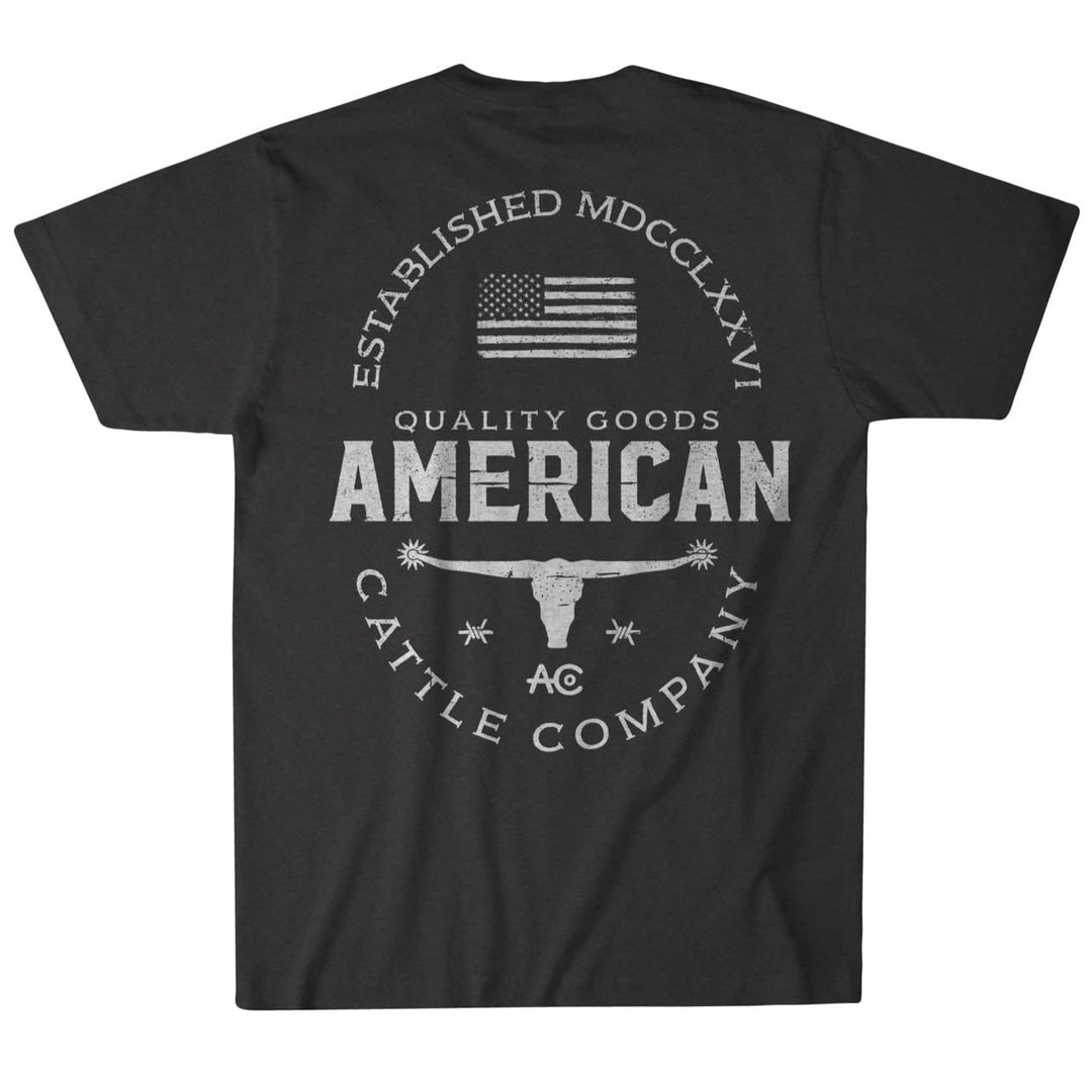 The Rural Cloth "Quality Goods Tee" is a black T-shirt with a circular design featuring an American flag, "Established MDCCLXXVI," and "American Cattle Company." Made from super soft cotton in the USA, it highlights a central longhorn skull to honor American cattle ranchers.