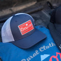 Two caps and a T-shirt are spread out on a textured surface. One cap, described as the 