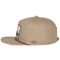 The Roper Hat by Rural Cloth is a beige flat-brim cap featuring a cowboy and bull patch on the front, red 