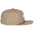 The Roper Hat by Rural Cloth is a beige baseball cap with a flat brim, featuring a stitched rectangular patch with an illustration and text. It has a button on top and is made from textured fabric, blending modern style with Western-inspired charm.