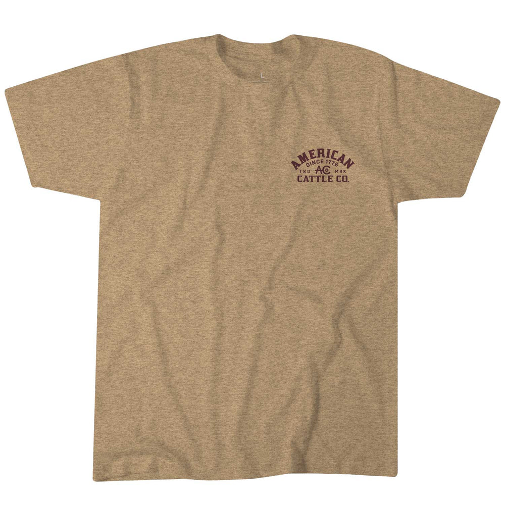 The beige Shadowhorn Tee by Rural Cloth showcases a small "American Cattle Co." text logo curved around "AC" on the left chest, reflecting a cattleman’s code. With its plain design and casual style, it’s a timeless piece for any wardrobe.
