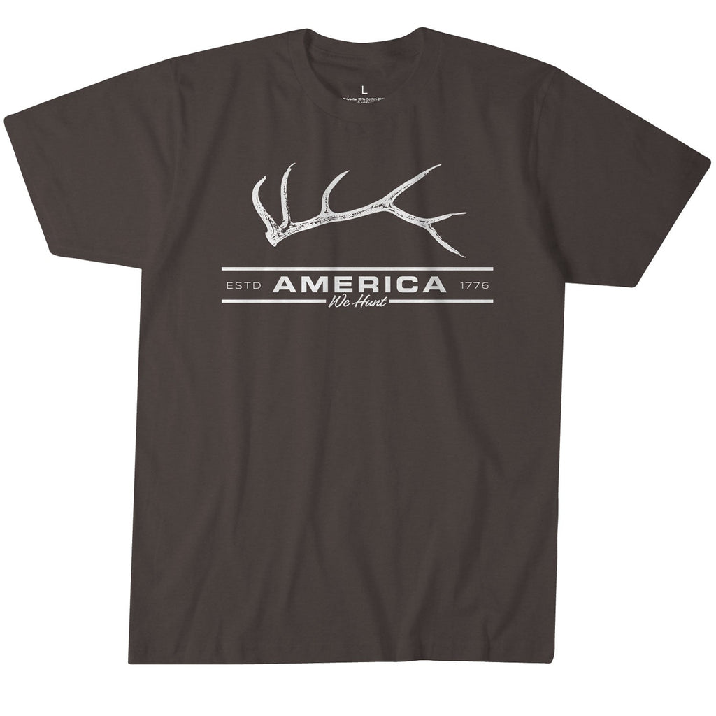 The Showoff Elk Tee from Rural Cloth is a dark brown t-shirt made of ultra-soft combed ring-spun cotton. It features a white printed design with an antler above the words 