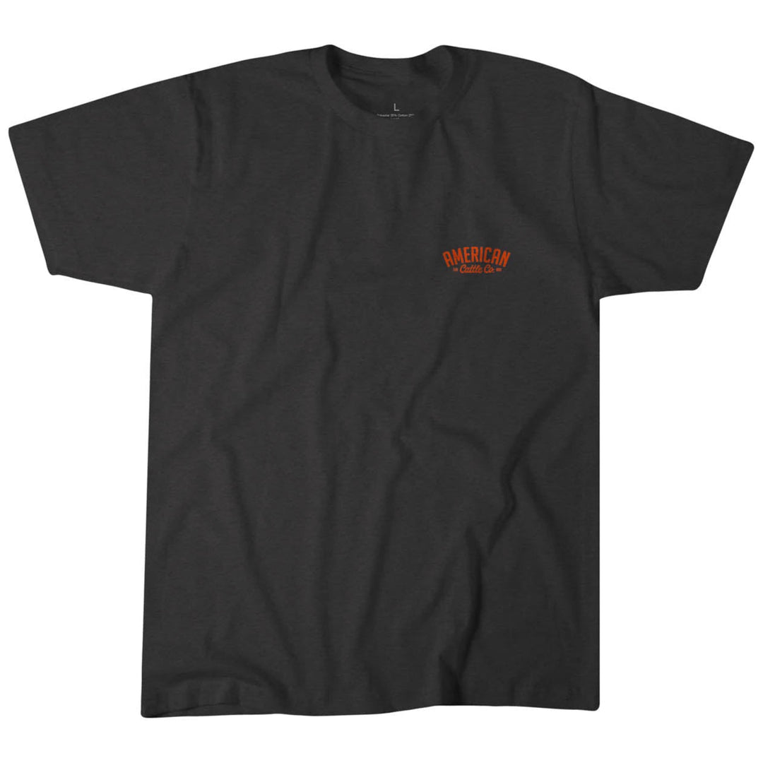 The Sunset Tee by Rural Cloth is a plain black T-shirt in a contemporary fit, featuring "AMERICAN" and orange text on the upper left front. Made from super soft cotton, it offers comfort and captures the hues of a western sunset.