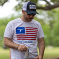 A man wearing a white T-shirt featuring an American flag and 