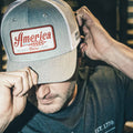 A person is adjusting the brim of their We Grow Coors Light Hat, featuring a red and white patch that reads 