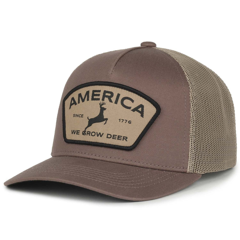 The "We Grow Deer Badge Hat" by Rural Cloth is a pewter and khaki mesh trucker snapback that features a patch on the front. The patch displays a deer silhouette and reads "AMERICA SINCE 1776 WE GROW DEER." Ideal for outdoor enthusiasts, the front of the hat is solid pewter, while the back is made of khaki mesh.