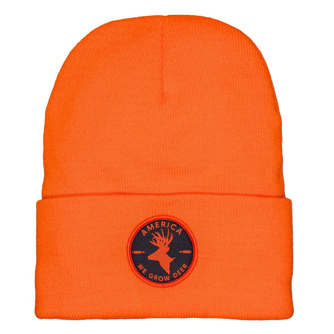 The We Grow Deer Beanie-Orange with Black Patch by Rural Cloth is an ideal choice for outdoor enthusiasts. It features a circular patch depicting a silhouette of a deer's head with antlers and the phrase "America We Grow Deer," making it perfect for fans of American deer hunting.