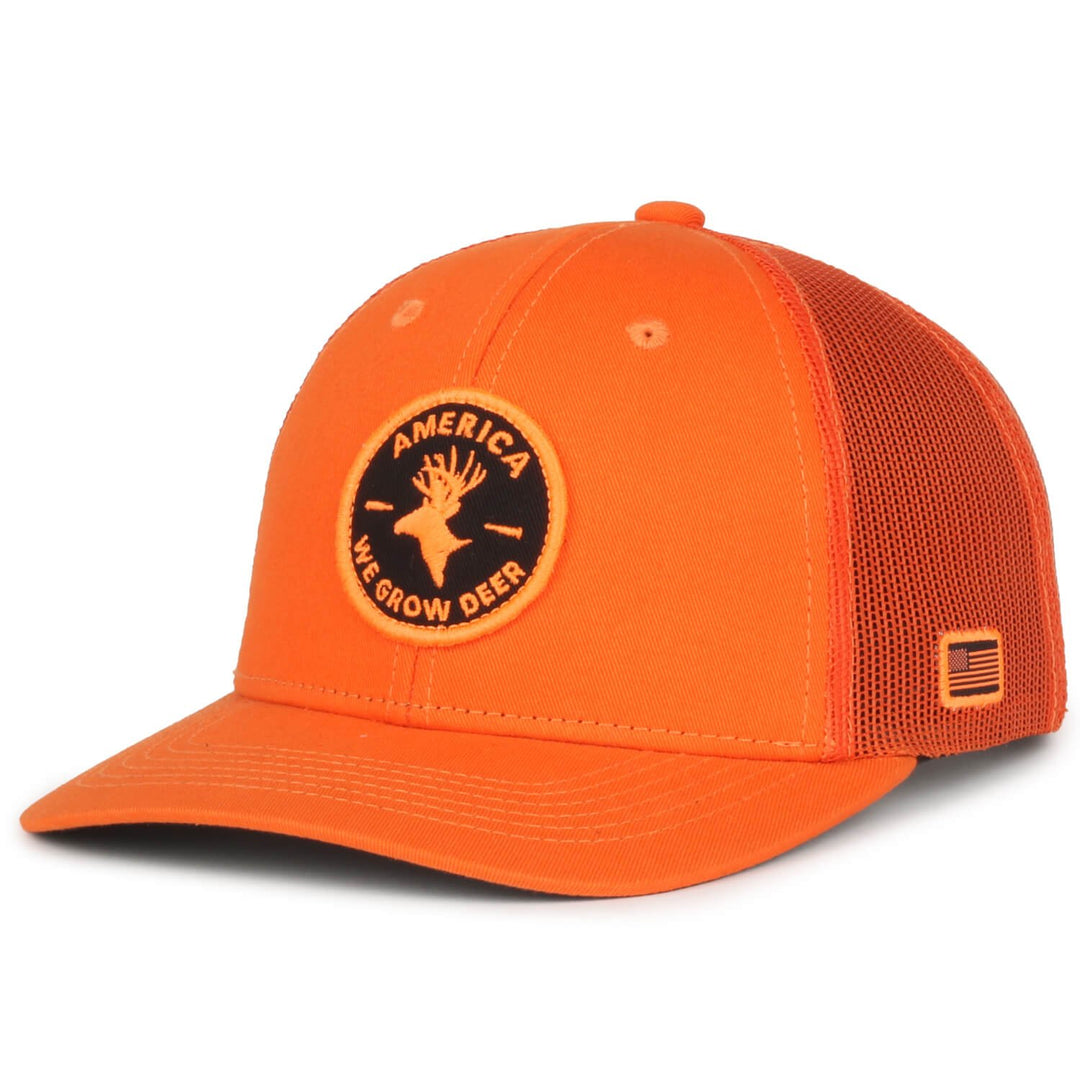 The We Grow Deer Hat by Rural Cloth is an orange snapback with a red mesh back, featuring a round patch on the front that depicts a deer and reads America We Grow Deer, making it perfect for the outdoorsman. Additionally, an American flag patch is attached to the left side of the mesh.