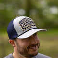 A man wearing a We Grow Whiskey Hat-Gray by Rural Cloth, with 