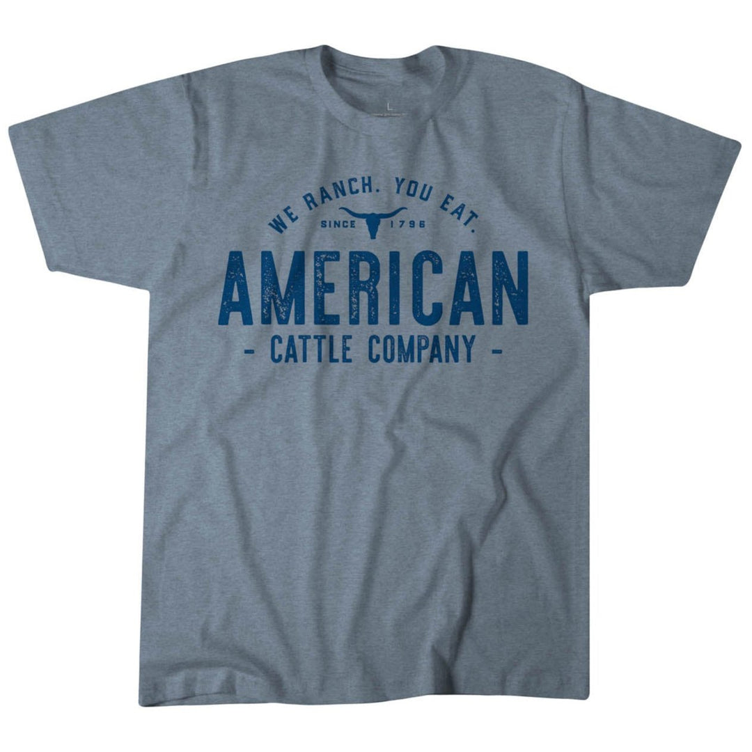 The "We Ranch You Eat V2 Tee" by Rural Cloth is a gray t-shirt made from premium weight fabric featuring blue text saying "We Ranch. You Eat. American Cattle Company" and "Since 1994." It offers a contemporary fit with timeless style.