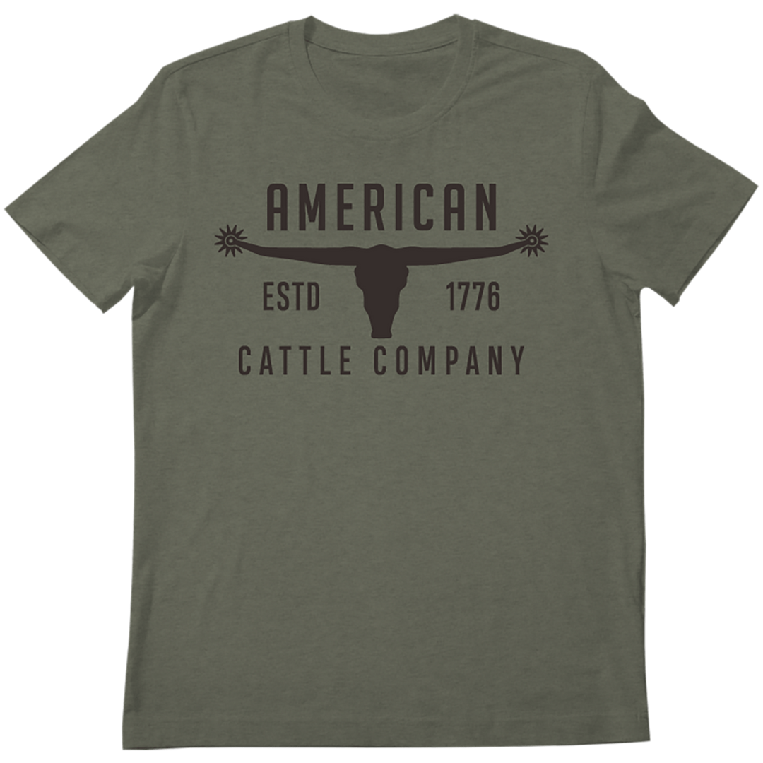 The Bull Spurs Tee in Heather Sage from Rural Cloth features Western symbolism with the text "AMERICAN CATTLE COMPANY ESTD 1776" in black and a graphic of a longhorn steer between "AMERICAN" and "ESTD 1776," capturing a rugged spirit.