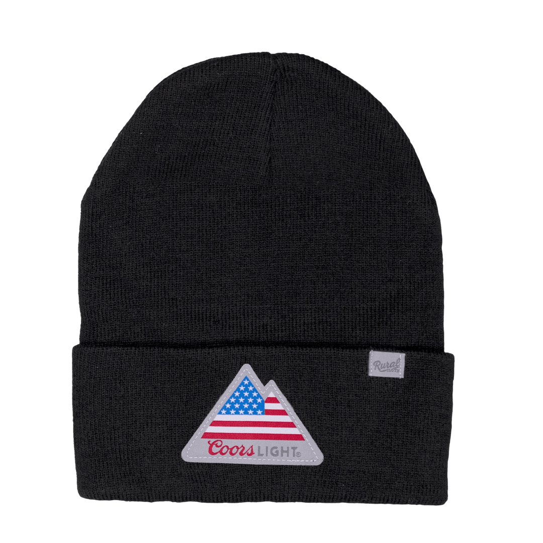 The Rocky Mountain Flag Beanie by Rural Cloth is a black knit beanie with a folded brim, featuring a front patch that displays a triangular design with an American flag pattern and "Coors Light" written in red script. This extra warm beanie also has a small beige tag with text sewn onto the left side of the brim.