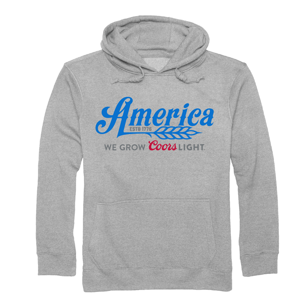 The We Grow Coors Light Pullover-Gray from Rural Cloth is a light gray hooded sweatshirt with the text "America ESTB 1776" in blue, and "We Grow Coors Light" in dark gray and red. Perfect for fans of American beer, the pullover features a front pocket and drawstrings at the hood.